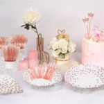 A complete set of AIRE rose gold polka dot disposable dinnerware, including plates, cups, napkins, and cutlery, arranged eleg