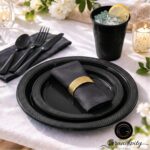 Complete black disposable dinnerware set with plates, cups, napkins, forks, knives, and spoons neatly arranged.