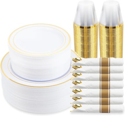 A full place setting of M MCIRCO gold-rimmed plastic dinner plates, salad plates, gold plastic silverware, and a clear gold-r