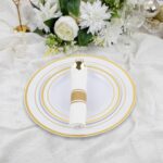 A full place setting of M MCIRCO gold-rimmed plastic dinner plates, salad plates, gold plastic silverware, and a clear gold-r