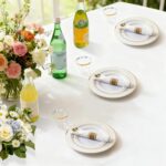 A full place setting of M MCIRCO gold-rimmed plastic dinner plates, salad plates, gold plastic silverware, and a clear gold-r