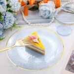 Rubtlamp 175-piece blue plastic dinnerware set with gold rim, including plates, cups, cutlery, and napkins for a party.